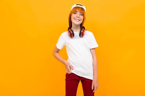 Schattig Gember Meisje Poseren Tegen Oranje Achtergrond Met Hoofdtelefoon — Stockfoto