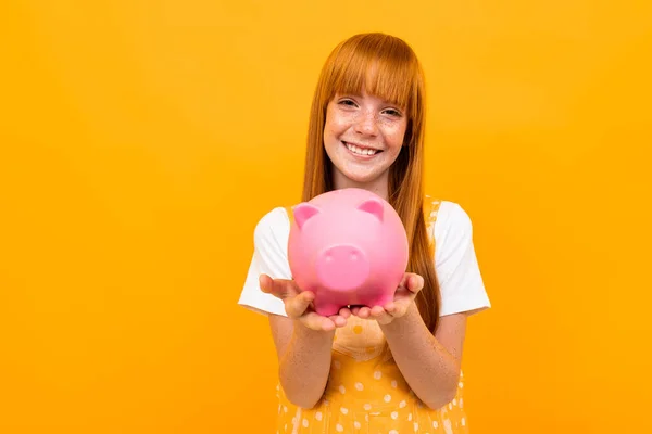 Cute Girl Piggy Bank Orange Background — Stock fotografie