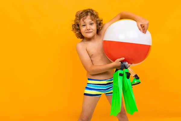 在橙色背景下摆出海滩造型的小男孩 — 图库照片