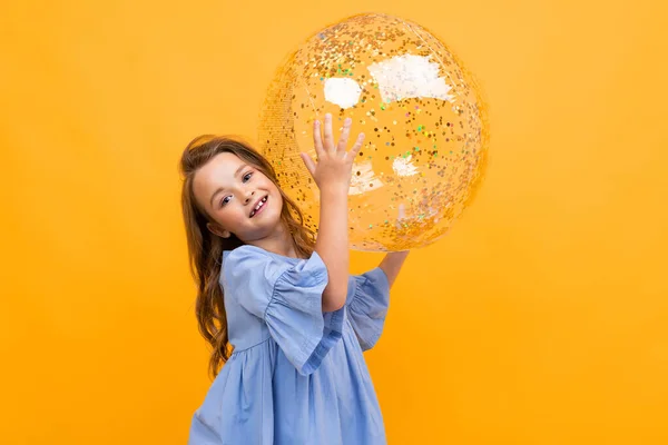 Cute Little Girl Piłką Pozowanie Pomarańczowym Tle — Zdjęcie stockowe