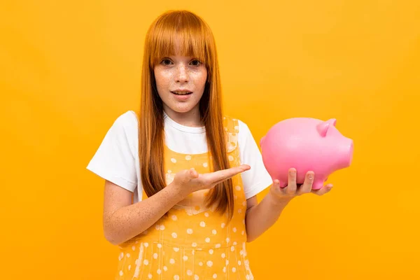 Cute Girl Piggy Bank Orange Background — Stock fotografie