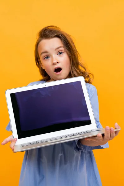 Linda Niña Con Portátil Contra Fondo Naranja —  Fotos de Stock