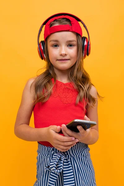 Linda Niña Escuchando Música Posando Sobre Fondo Naranja — Foto de Stock