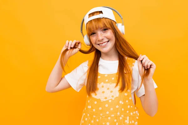 Vrolijk Gember Meisje Luisteren Naar Muziek Poseren Tegen Oranje Achtergrond — Stockfoto