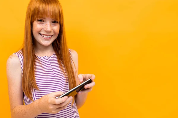 Menina Gengibre Com Smartphone Contra Fundo Laranja — Fotografia de Stock