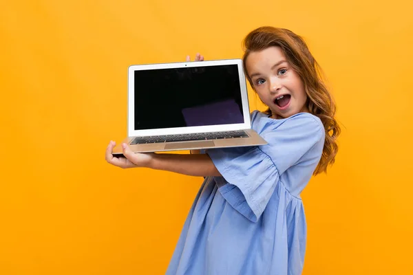 Carino Bambina Con Computer Portatile Contro Arancione Sfondo — Foto Stock