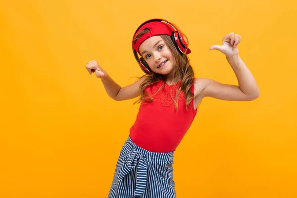 Linda Niña Escuchando Música Posando Sobre Fondo Naranja — Foto de Stock