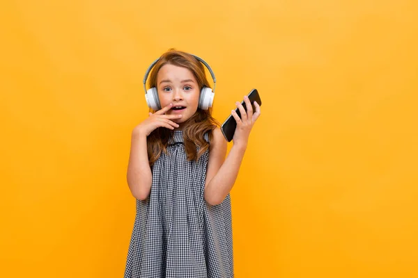 Linda Niña Escuchando Música Posando Sobre Fondo Naranja — Foto de Stock