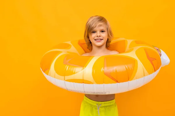 可爱的小男孩 戴着橡胶圈 背对着橙色的背景 — 图库照片