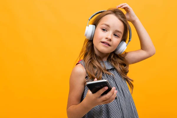 Linda Niña Escuchando Música Posando Sobre Fondo Naranja — Foto de Stock