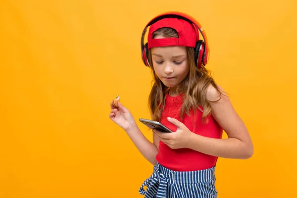 Cute Little Girl Słuchanie Muzyki Pozowanie Pomarańczowym Tle — Zdjęcie stockowe