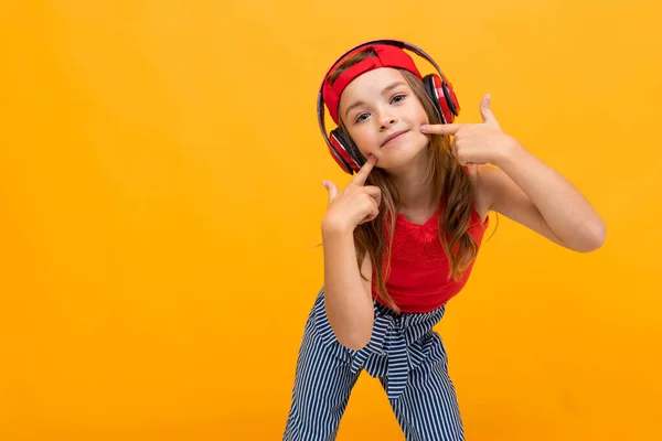 Linda Niña Escuchando Música Posando Sobre Fondo Naranja — Foto de Stock