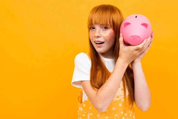 Cute Girl Piggy Bank Orange Background — Stock fotografie