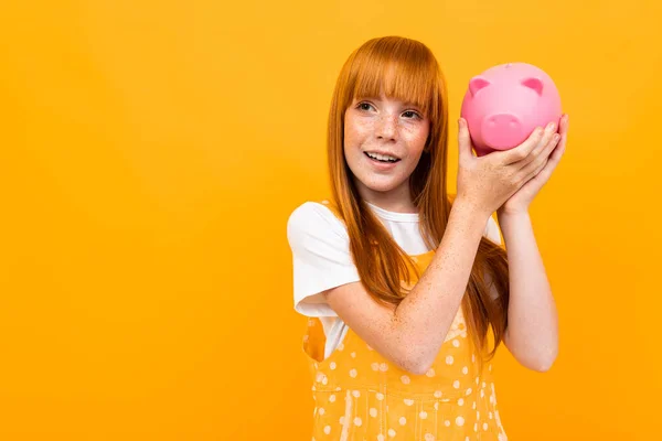 Cute Girl Piggy Bank Orange Background — Zdjęcie stockowe