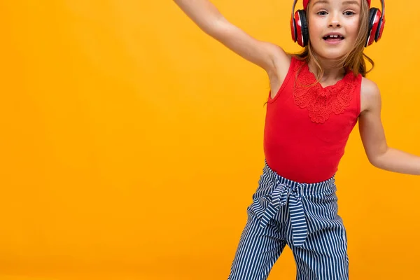 Cute Little Girl Słuchanie Muzyki Pozowanie Pomarańczowym Tle — Zdjęcie stockowe