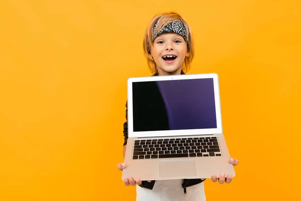 Portakala Karşı Poz Veren Dizüstü Bilgisayarlı Çocuk — Stok fotoğraf