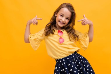 Turuncuya karşı poz veren hoş, şık bir kız. 