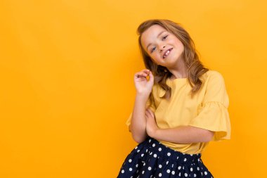 Turuncuya karşı poz veren hoş, şık bir kız. 