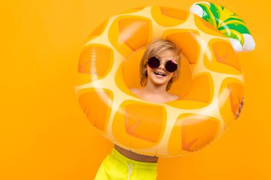 Turuncuya karşı lastik halkalı sevimli çocuk. 