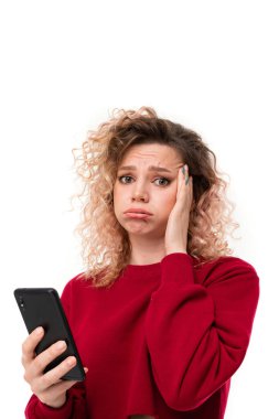 Beyaz arka planda cep telefonuyla poz veren genç kadın  