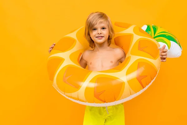可爱的小男孩 戴着橡胶圈 背对着橙色的背景 — 图库照片
