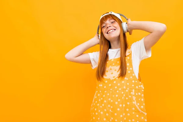 Alegre Jengibre Chica Escuchar Música Posando Sobre Naranja Fondo — Foto de Stock