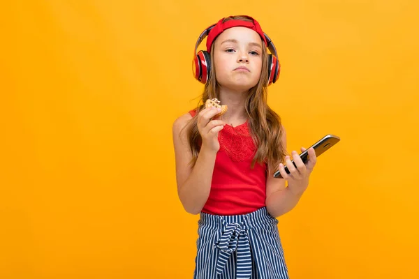 Linda Niña Escuchando Música Posando Sobre Fondo Naranja — Foto de Stock