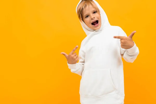 Menino Emocional Com Capuz Branco Posando Contra Fundo Laranja — Fotografia de Stock