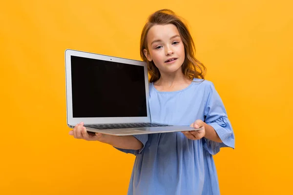 Cute Little Girl Laptopem Pomarańczowym Tle — Zdjęcie stockowe