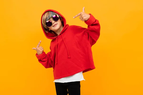 Menino Elegante Bonito Vestindo Capuz Vermelho Óculos Sol Posando Contra — Fotografia de Stock