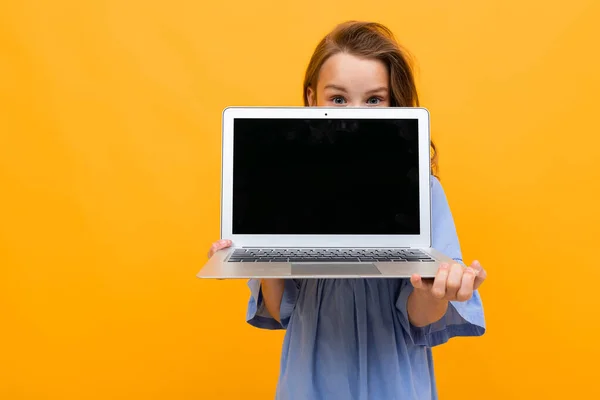 Cute Little Girl Laptopem Pomarańczowym Tle — Zdjęcie stockowe
