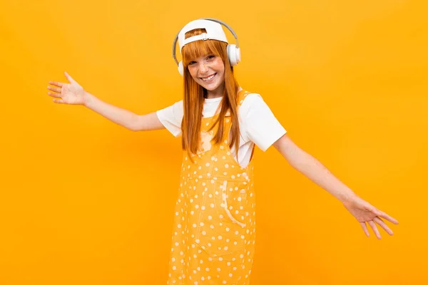 Gadis Jahe Ceria Mendengarkan Musik Berpose Terhadap Latar Belakang Oranye — Stok Foto