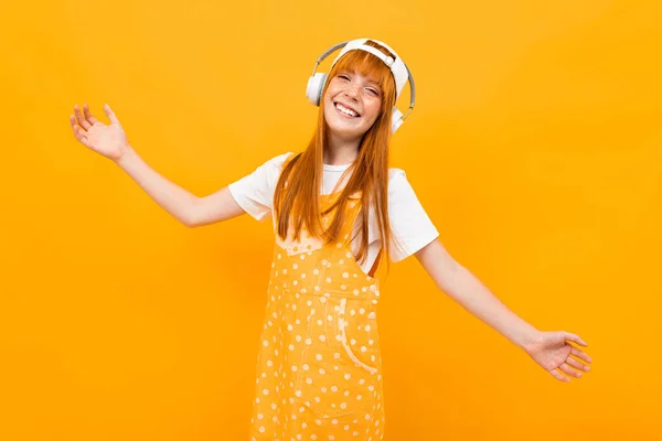 Alegre Jengibre Chica Escuchar Música Posando Sobre Naranja Fondo — Foto de Stock