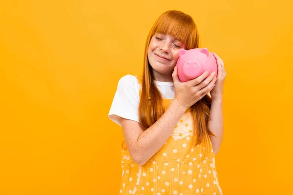 Cute Girl Piggy Bank Orange Background — Stock fotografie