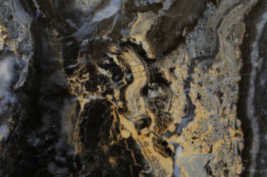 Çekici soyut desenleri ve zengin dokuları gösteren doğal bir taş yüzeyinin yakın görüntüsü.