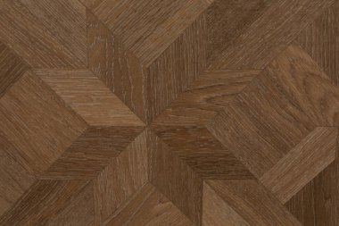 Bu ahşap parke döşeme, kahverenginin değişik tonlarında geometrik bir desen içeriyor ve odada sıcak bir atmosfer yaratıyor. Modern ve geleneksel iç mekanlar için ideal..