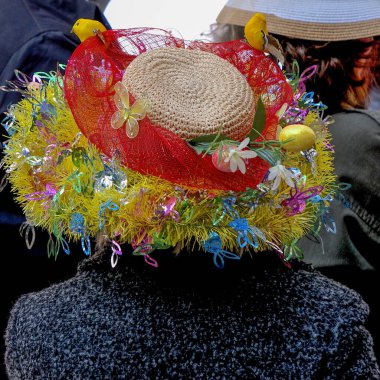 Sarı, mavi, pembe ve kırmızı çiçekli Paskalya şapkası. Geleneksel New York Şehri Beşinci Cadde Paskalya Geçidi 'nde kuşlar ve kelebekler var..