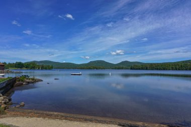 Adirondack Park, New York: Mavi Dağ 'ın kıyılarına olan uzaklıktaki mavi dağ manzarası, yukarıdaki derin mavi gökyüzünde bulutlar.