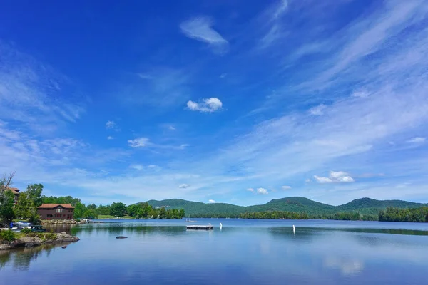 Adirondack Park, New York: Mavi Dağ 'ın kıyılarına olan uzaklıktaki mavi dağ manzarası, yukarıdaki derin mavi gökyüzünde bulutlar.