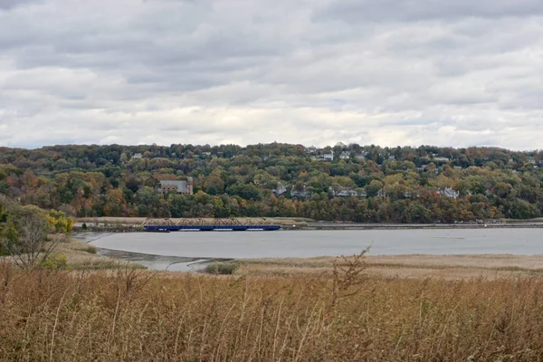 Westchester, NY: Hudson Nehri üzerinde bir körfez boyunca uzanan bir demiryolu köprüsü, arka planda St. Augustines Roma Katolik Kilisesi, Ossining, New York.