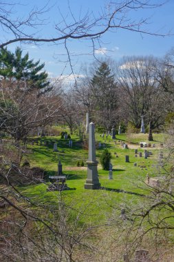 Brooklyn, New York: Obeliskler ve mezar taşları, 1838 yılında kurulan tarihi Green-Wood Mezarlığı 'nın gölgeli bir bölümünde ağaç dalları arasında görülüyor.