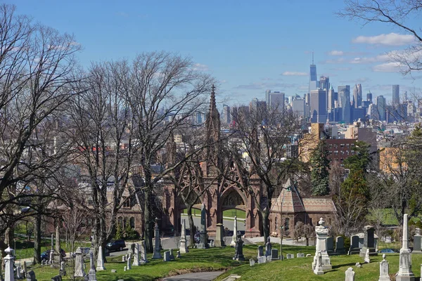 Brooklyn, New York: Bir Dünya Ticaret Merkezi (nam-ı diğer Özgürlük Kulesi) ve Manhattan silueti, 1838 yılında kurulan tarihi Yeşil Ahşap Mezarlığı 'nın Gotik girişinin üzerinde görülüyor..