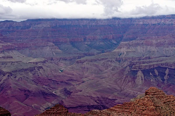 亚利桑那州大峡谷国家公园 大峡谷的深紫色 红色和褐色在低云覆盖下 从南缘的沙漠景观区域可以看到 — 图库照片