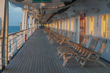 Akşamüstü bir yolcu gemisinin güvertesinde uzun bir sıra boş iskemle..