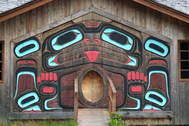 Ketchikan, Alaska: Potlatch Totem Parkı 'ndaki klan evinin dışı, totemleri, oyma kulübeleri ve tarihi sergileriyle yeniden yaratılmış bir Tlingit köyü..
