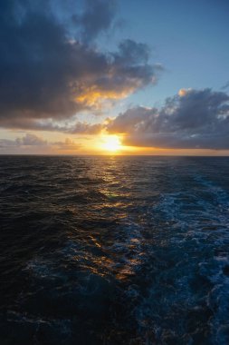 Güneş, Sitka, Alaska ve Victoria, British Columbia, Kanada arasındaki Kuzey Pasifik Okyanusu 'ndan batarken ufukta yoğun beyaz bulutlar beliriyor..