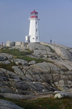 Peggys Koyu, Nova Scotia, Kanada: Ziyaretçiler Peggys Point Deniz fenerini geziyor, 1914, sabah sisiyle örtülü..
