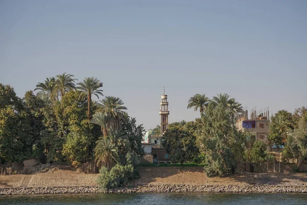 Nile River, Egypt: A minaret and houses on the east bank of the Nile River.