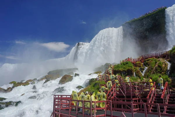 Niagara Şelalesi, New York: Sarı yağmurluklu turistler, Keçi Adası 'ndaki Rüzgâr Mağarası' nın, merdivenlerin ve platformların keyfini çıkarıyorlar..