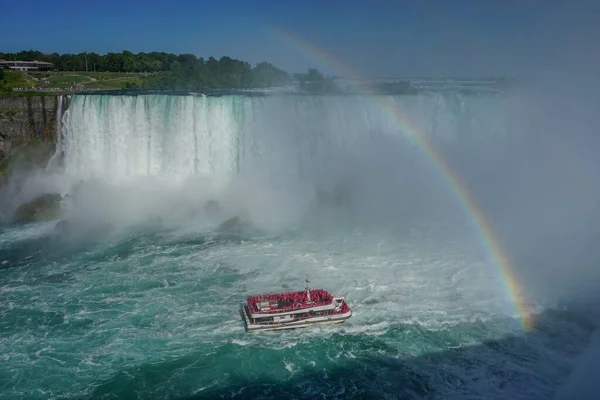 カナダのオンタリオ州ナイアガラの滝 ツアーボートがホースシュー滝のふもとに訪問者を連れて行くので ナイアガラ川の上に虹が表示されます — ストック写真